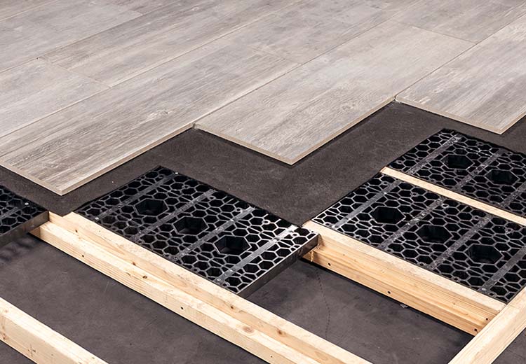 Hanover Gridloc™ system set between 2x4 wood frames with lining cloth, then porcelain pavers on top.