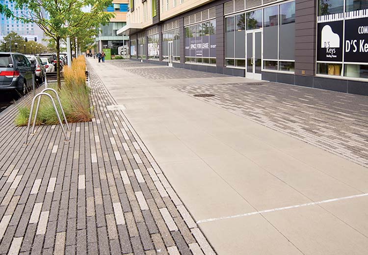 Hanover permeable bricks create a wide sidewalk area on either side of a cement pathway in front of a piano store