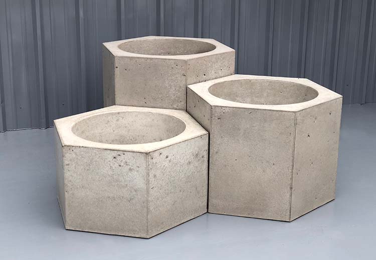 Three sizes of Form and Fiber Bloc concrete planters. The side walls form a hexagon.