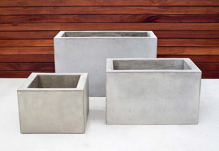 Three sizes of Form and Fiber concrete box planters in front of a redwood wall