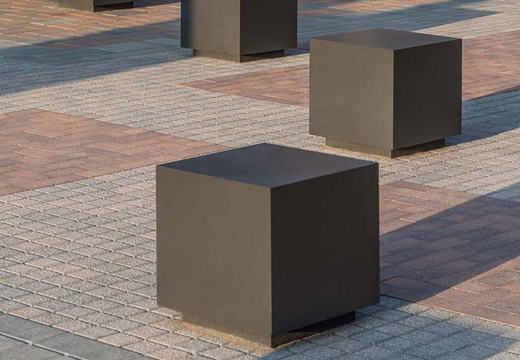 Form and Fiber custom steel cube bollards create a barrier, as well as seating, in an open plaza