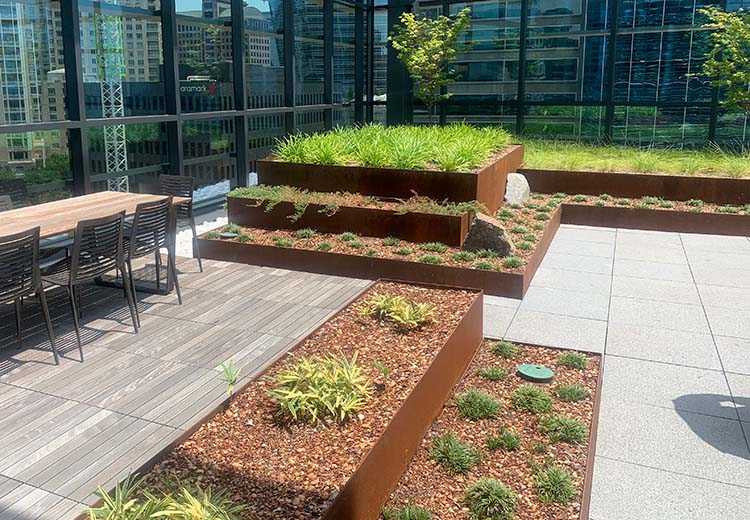 Two sets of tiered Corton steel Form and Fiber planter boxes in a corporate rooftop garden.
