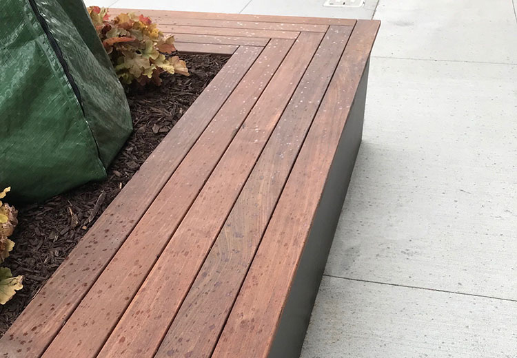 Close-up of Ipe Wood seating built into a Form and Fiber Sabine sidewalk planter